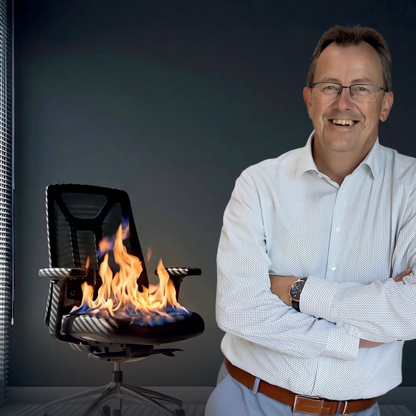 Wolfgang Frick mit verschränkten Armen neben einem brennenden Chefsessel